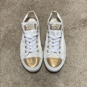Gold and white converse.